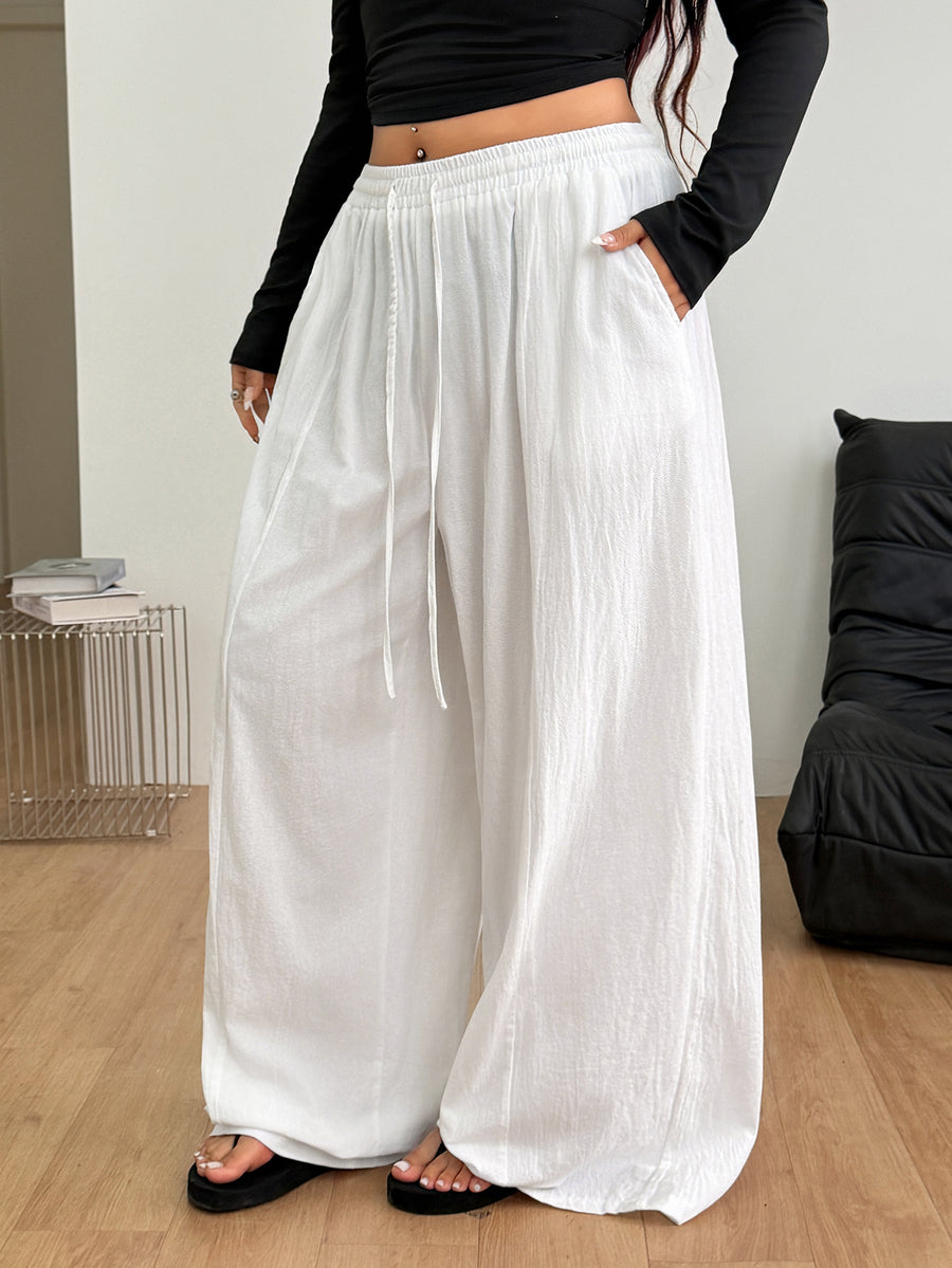 Women's loose straight leg cotton pants featuring a high waist with an adjustable drawstring knot and functional side pockets.