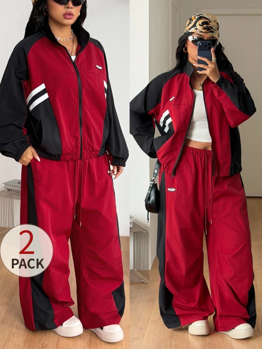 Women's plus size two-piece casual tracksuit set in black, featuring a loose-fit zip-up jacket with stand collar and matching cropped parachute pants.