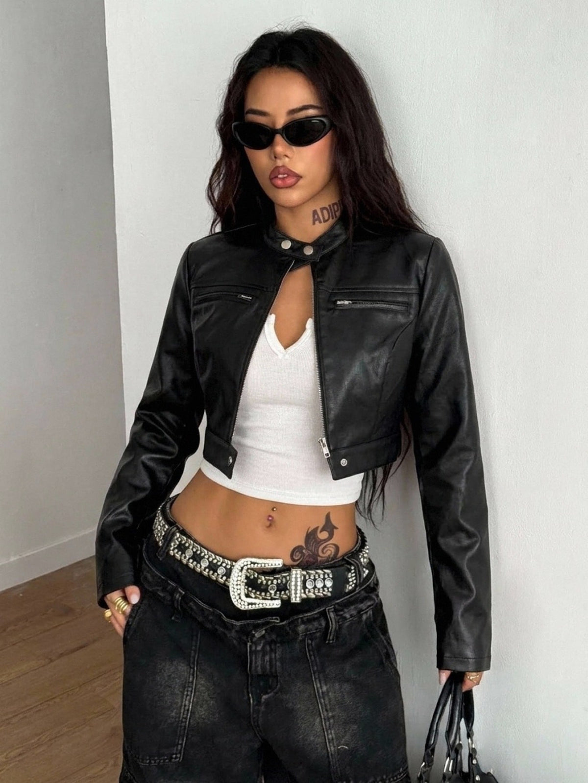 Front view of a women's black cropped PU leather jacket featuring a stand collar, long sleeves, and front zipper closure.