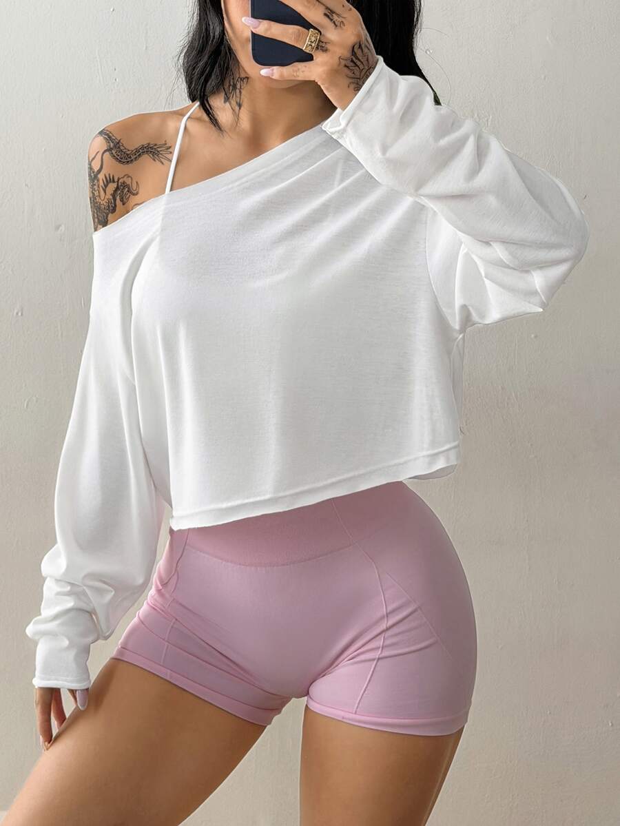 Women's white one shoulder rib-knit crop pullover top featuring an asymmetrical neckline, drop shoulder long sleeves, and a relaxed loose fit for yoga and athleisure wear.