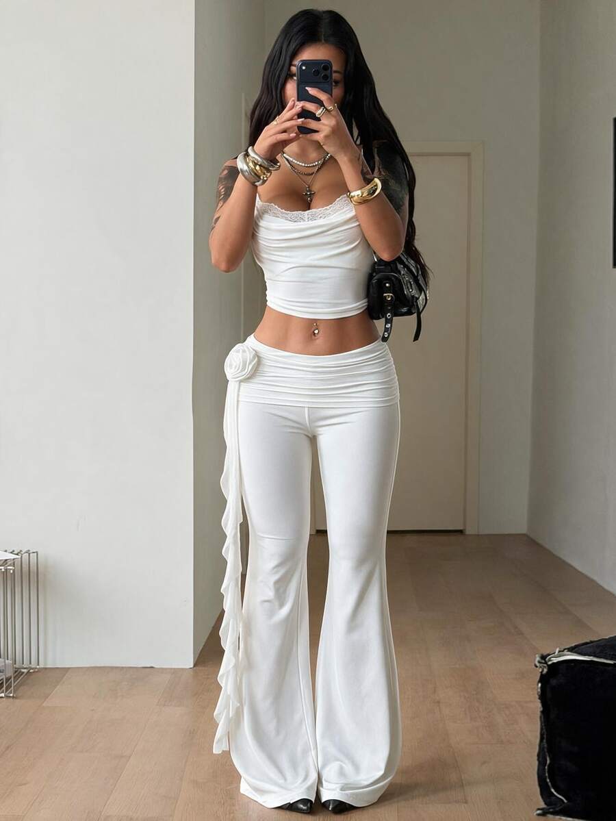 Black low waist flare pants featuring 3D rose and side stripe detailing in stretchy mesh fabric.