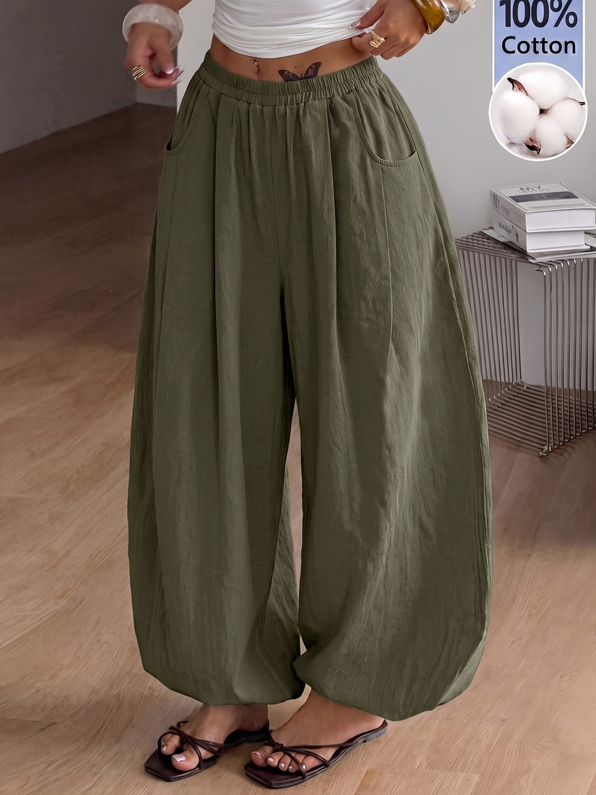 Women's loose-fit black bloomer pants made of 100% cotton featuring an elastic waistband and side pockets.