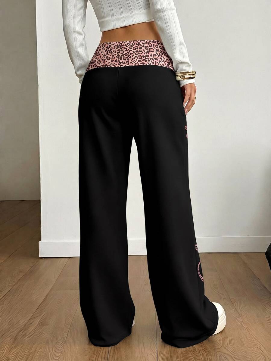 Women's black leopard print flare leg sweatpants with an elastic mid waist crafted from cotton knitted fabric.