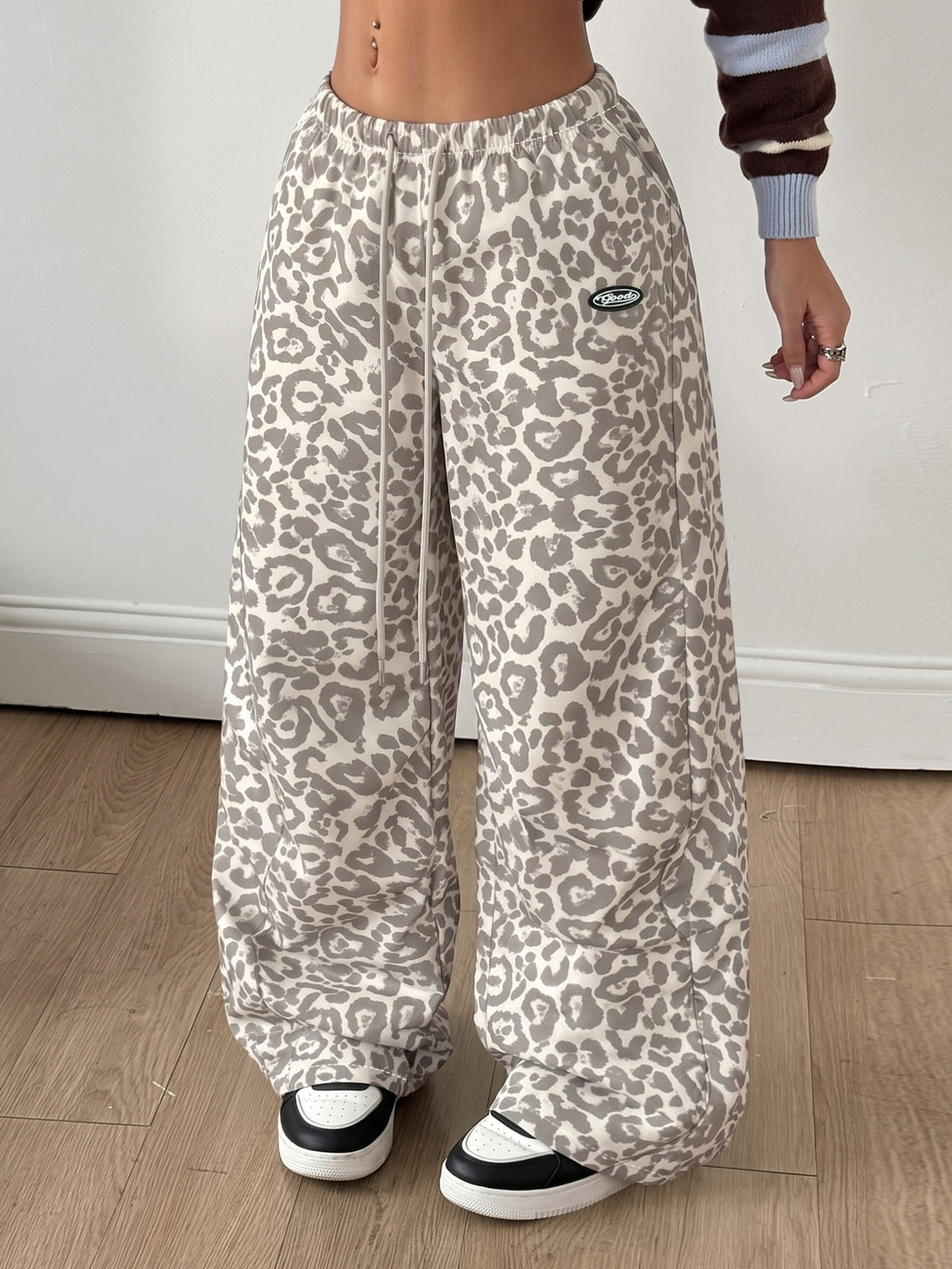 Women's black baggy jogger pants with an adjustable drawstring waist and colorblock polka dot geometric pattern.