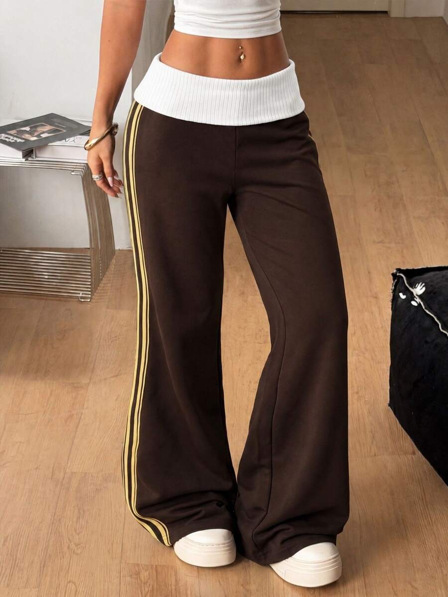 Women's wide leg flare sweatpants featuring a black and white colorblock contrast fold waistband and side stripe details.