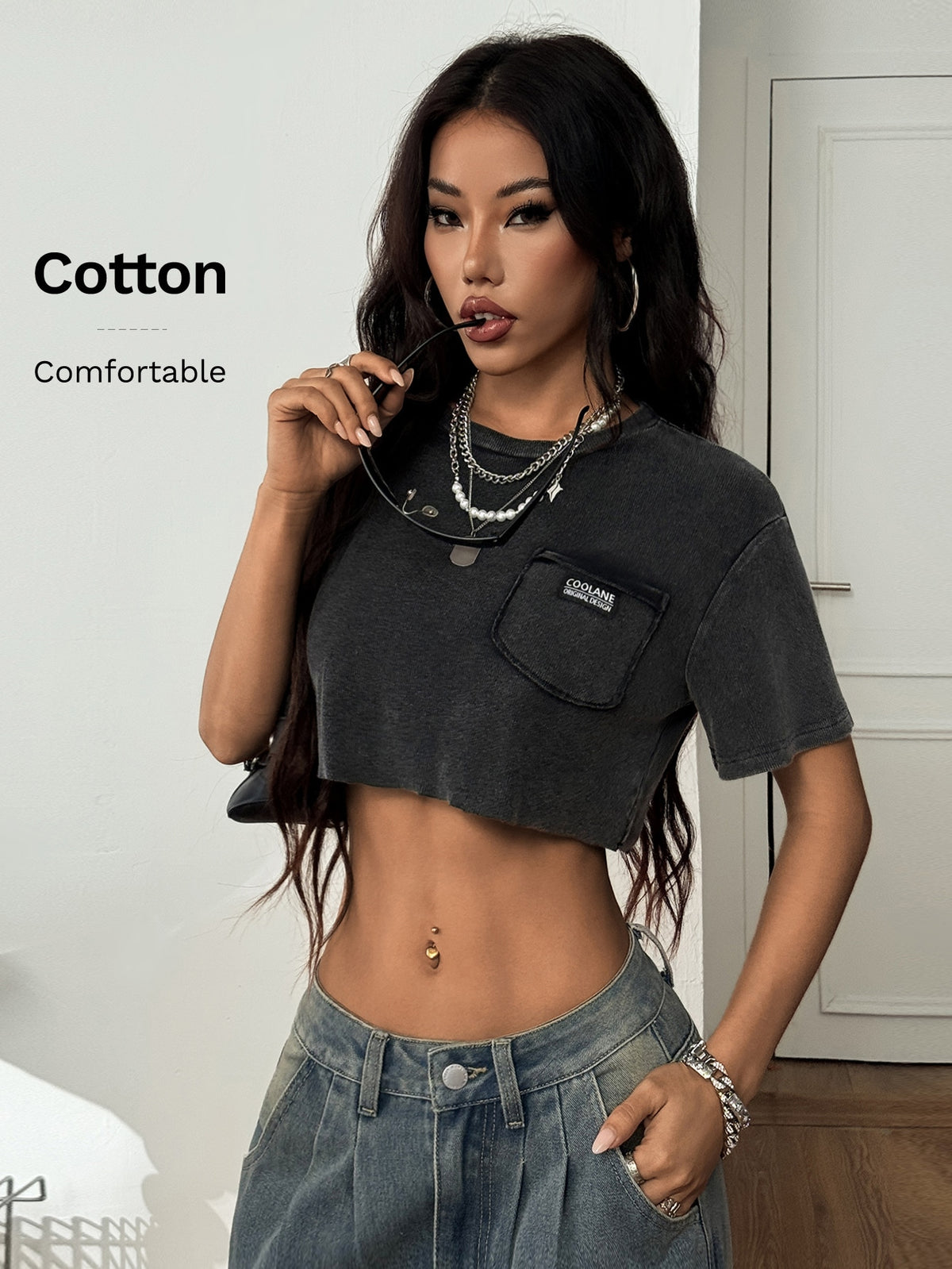Women's short sleeve crop top with a round neckline and drop shoulder design in black knitted fabric.
