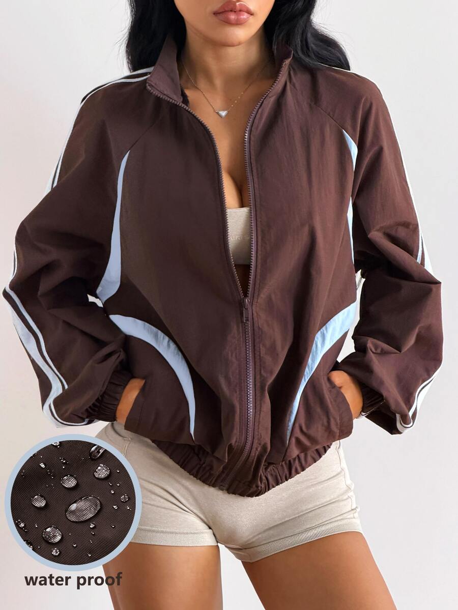 Front view of a women's oversized coffee brown sports jacket featuring a high neckline, front zipper closure, and long sleeves.