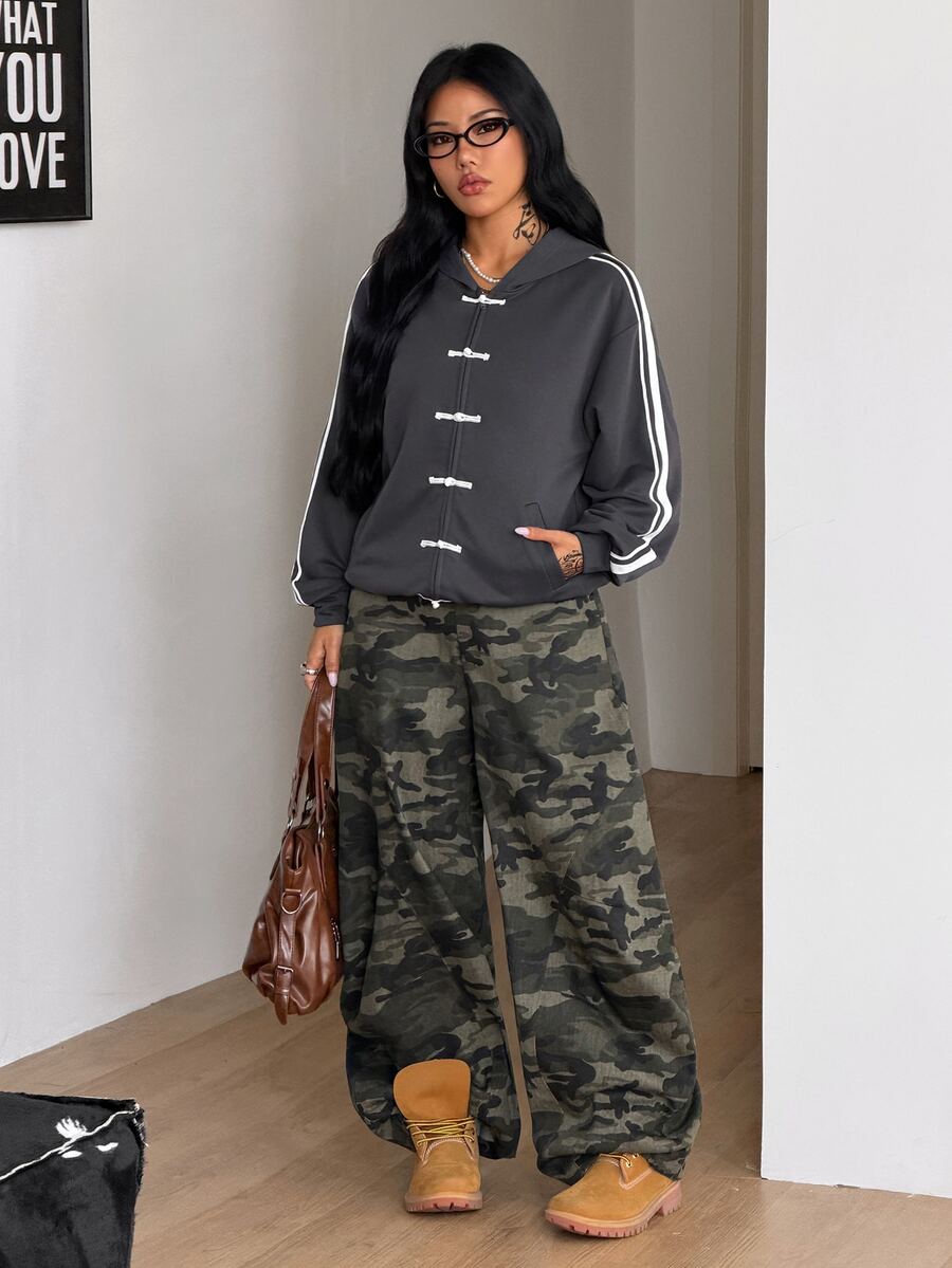 Women's army green camo zip up hoodie with drop shoulder sleeves, front pockets, and drawstring hood