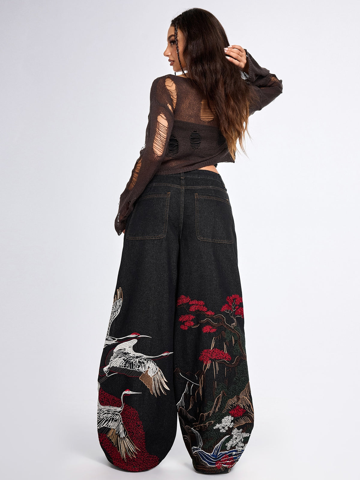 Women's black loose wide leg jeans with detailed crane and landscape embroidery, zipper fly, and ultra low waist.
