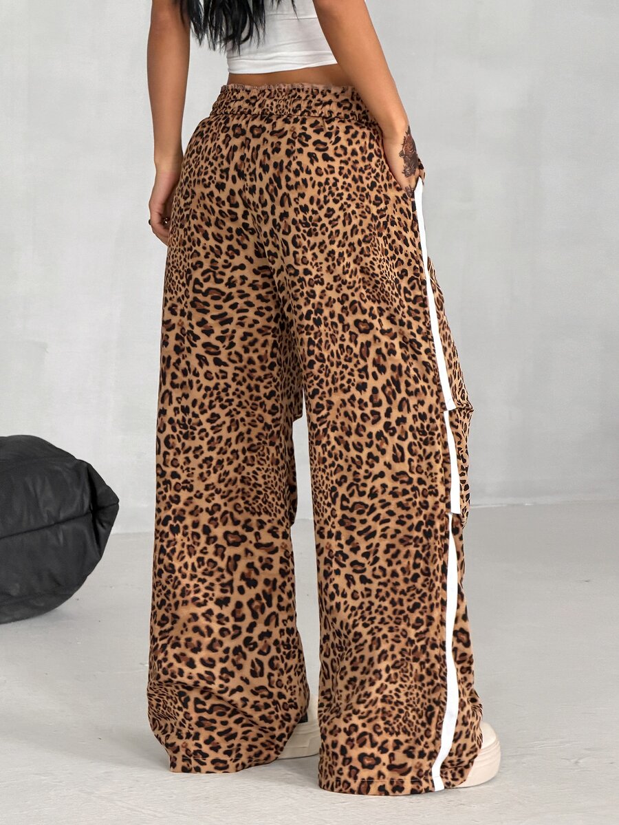 Women's black and white striped wide leg pants featuring an elastic drawstring waistband, side pockets, and a loose straight leg fit.