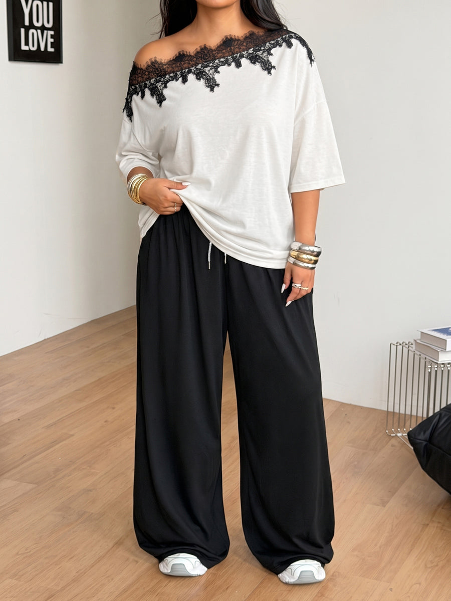Women's casual two-piece outfit featuring a loose short-sleeve asymmetrical neck t-shirt and matching long wide leg pants with pockets.