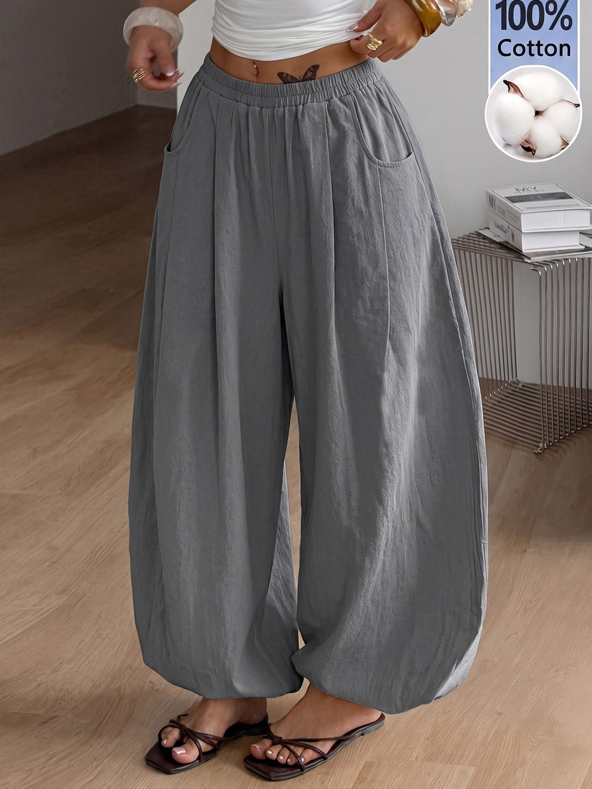 Women's loose-fit black bloomer pants made of 100% cotton featuring an elastic waistband and side pockets.