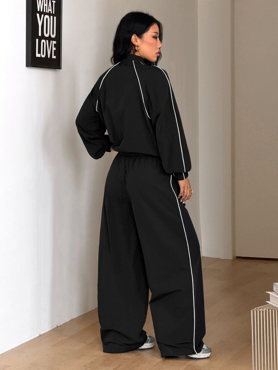 Women's black casual reflective windbreaker sports set featuring a loose stand collar zip jacket and matching unlined pants.