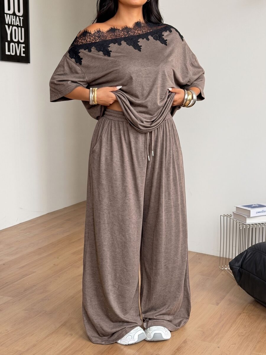 Women's casual two-piece outfit featuring a loose short-sleeve asymmetrical neck t-shirt and matching long wide leg pants with pockets.