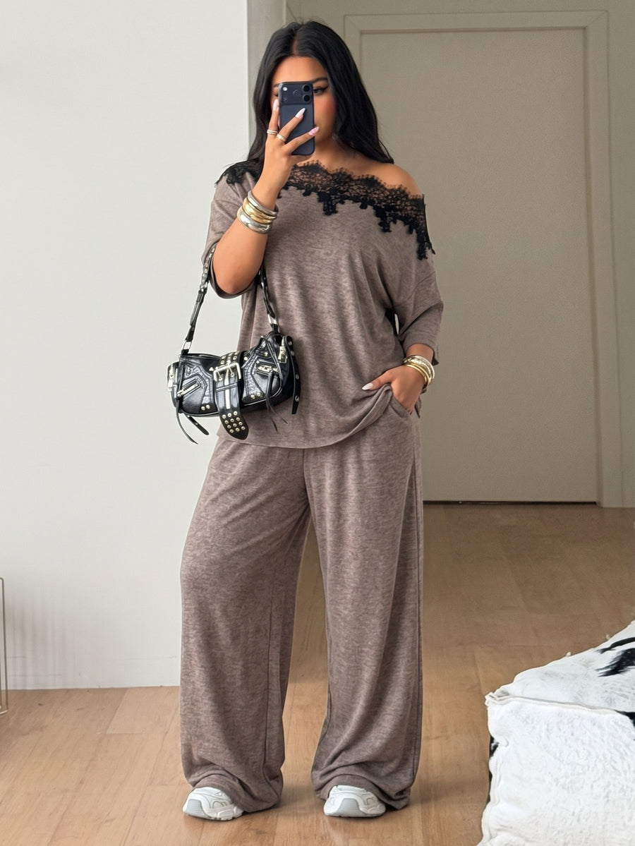Women's casual two-piece outfit featuring a loose short-sleeve asymmetrical neck t-shirt and matching long wide leg pants with pockets.