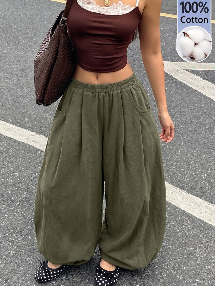 Women's loose-fit black bloomer pants made of 100% cotton featuring an elastic waistband and side pockets.