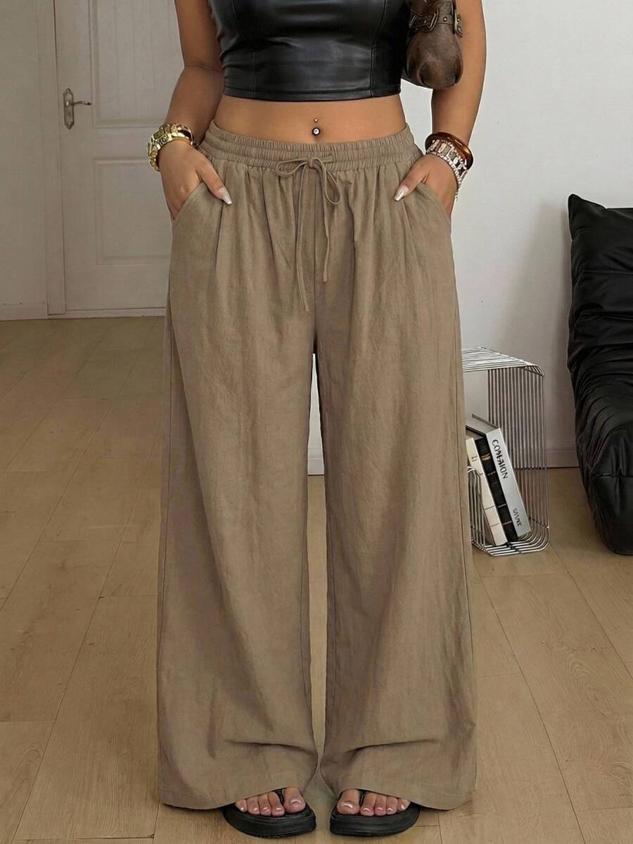 Women's loose straight leg cotton pants featuring a high waist with an adjustable drawstring knot and functional side pockets.