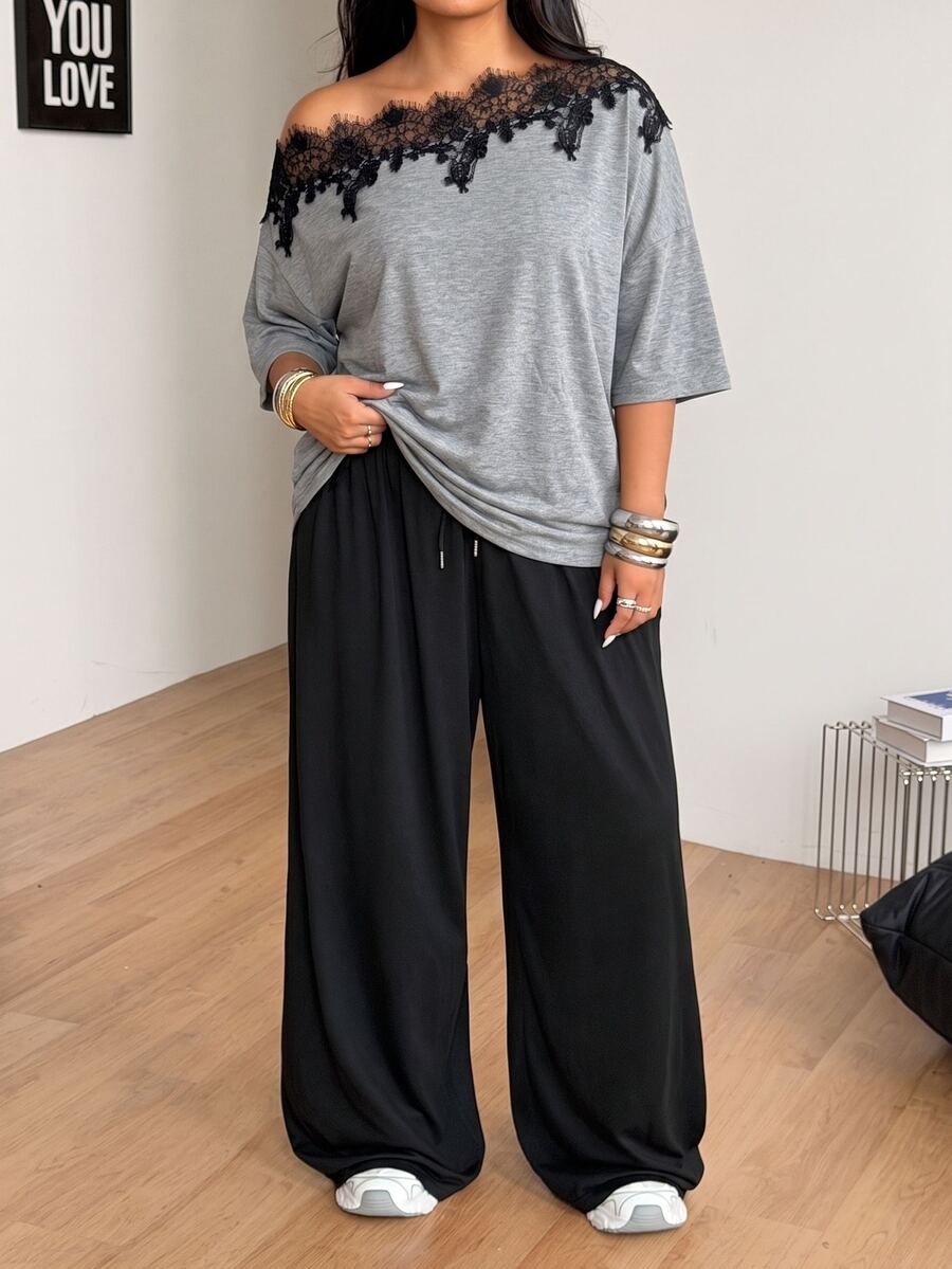Women's casual two-piece outfit featuring a loose short-sleeve asymmetrical neck t-shirt and matching long wide leg pants with pockets.