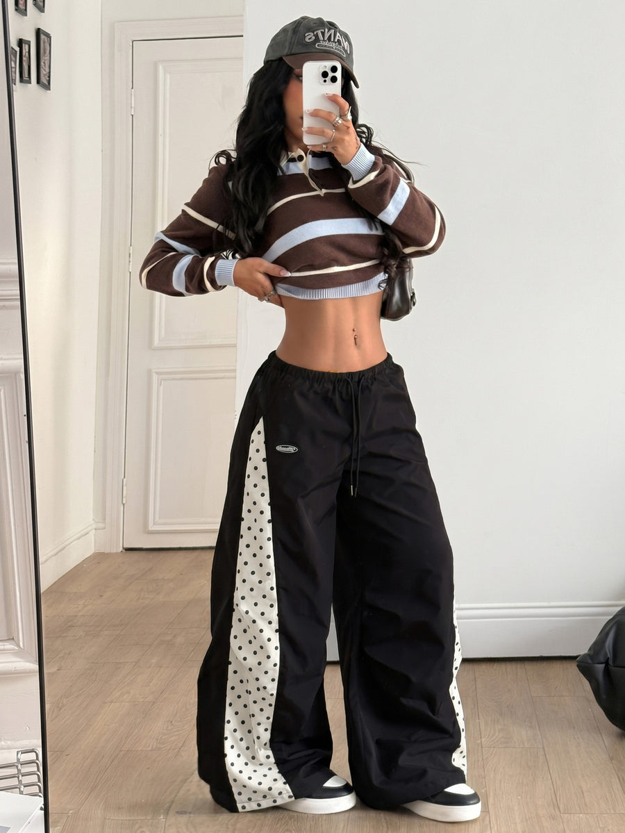 Women's black baggy jogger pants with an adjustable drawstring waist and colorblock polka dot geometric pattern.