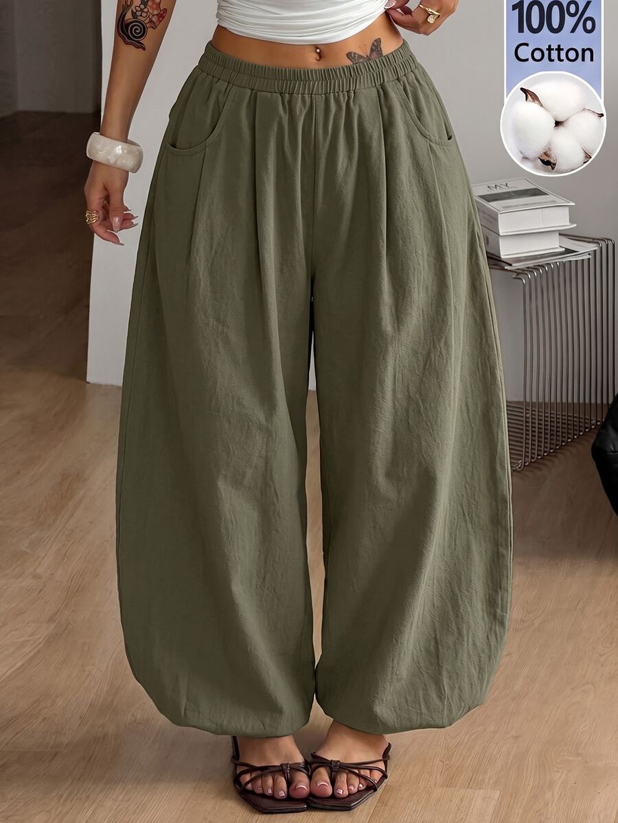 Women's loose-fit black bloomer pants made of 100% cotton featuring an elastic waistband and side pockets.