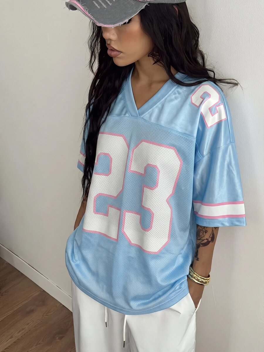 Oversized short-sleeve football jersey top featuring a V-neckline, contrast binding, and graphic number print.