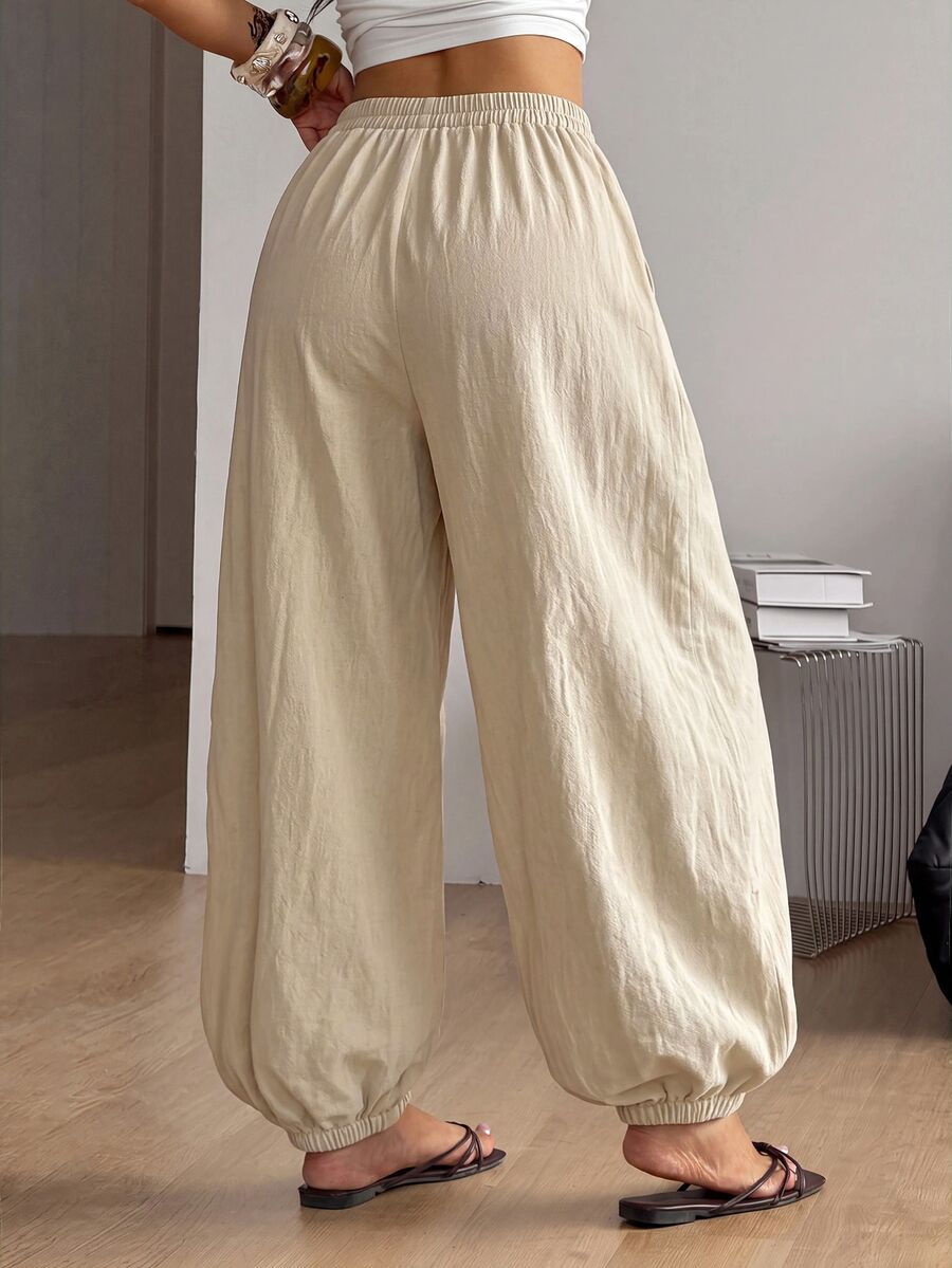 Women's loose-fit black bloomer pants made of 100% cotton featuring an elastic waistband and side pockets.