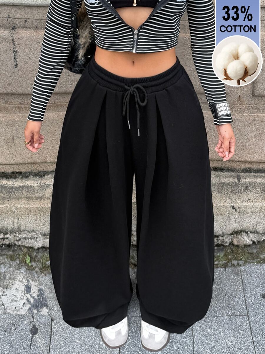 Women's casual black loose fit baggy banana pants featuring a low rise elastic drawstring waist and side pockets.