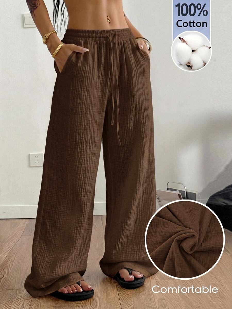 Women's black and white striped wide leg pants featuring an adjustable drawstring waist and side pockets.